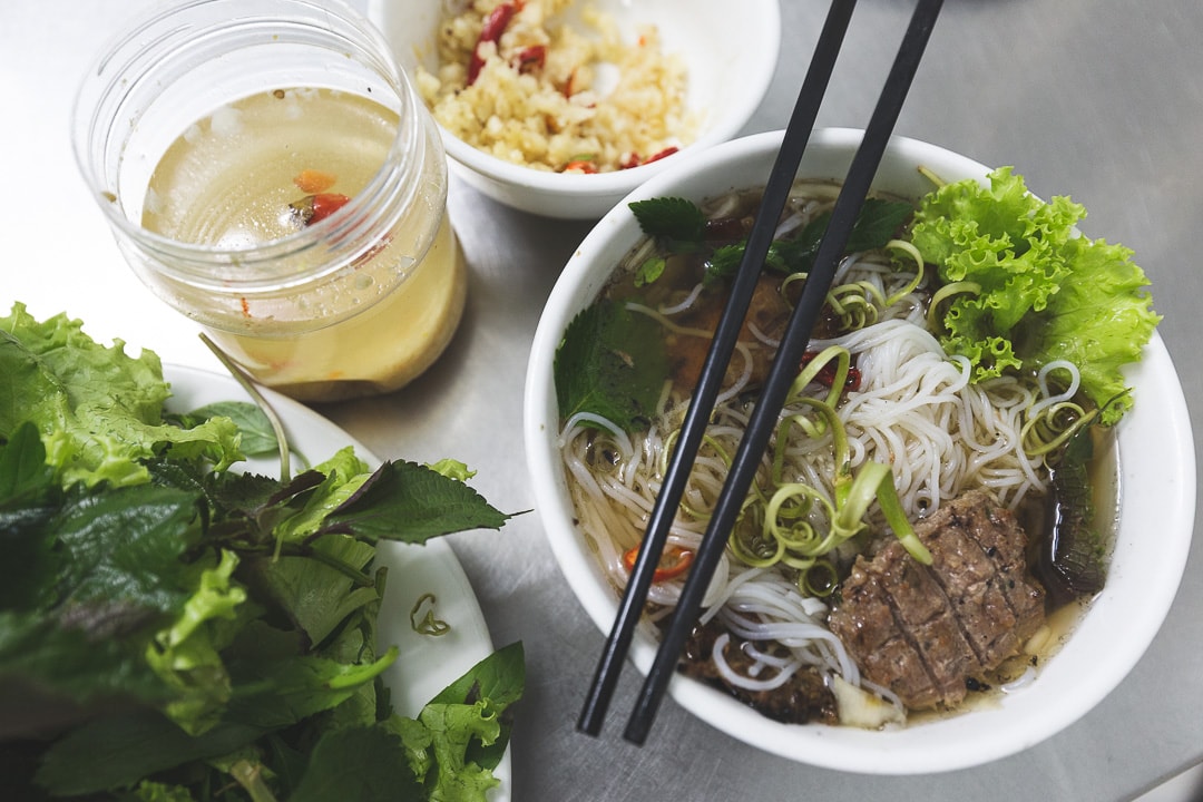 A bowl of Bun Cha with herbs and garlic. Vietnamese foods you must try in Hanoi.